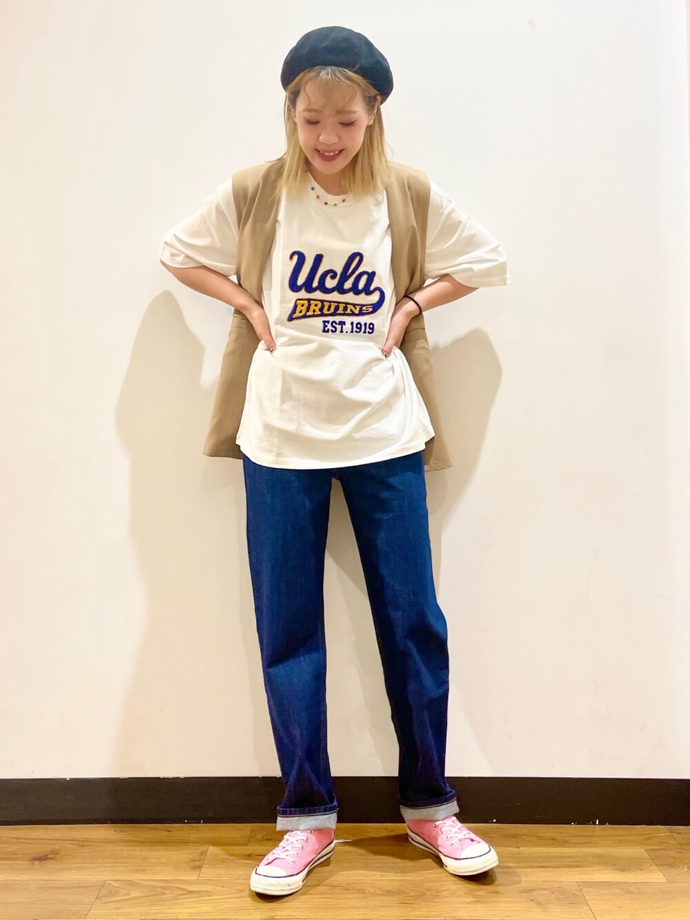 ホワイト系のTシャツ/カットソー、ベージュ系のベスト、ブルー系のデニムパンツを着用したレディースの春コーディネートの2枚目の写真