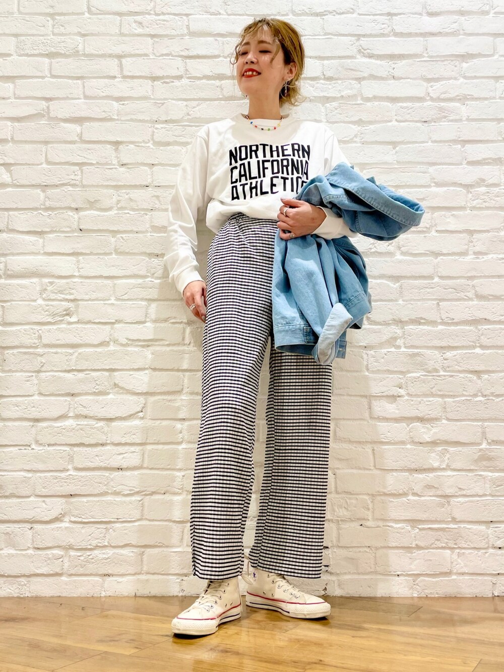 ブルー系のデニムジャケット、ホワイト系のTシャツ/カットソー、ホワイト系のスニーカーを着用したレディースの春コーディネートの3枚目の写真