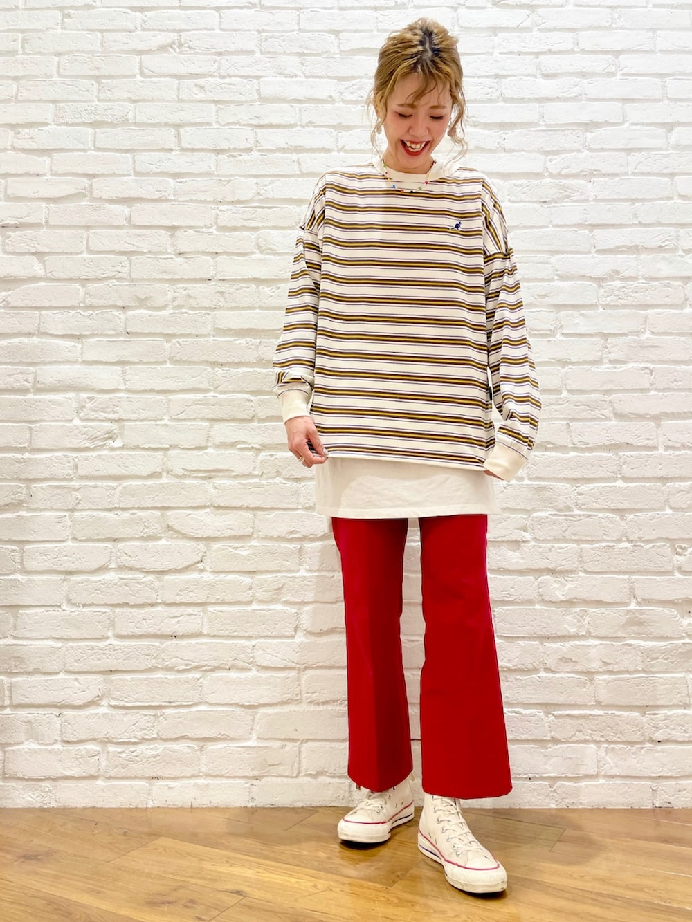 ホワイト系のTシャツ/カットソー、レッド系のスラックス、ホワイト系のスニーカーを着用したレディースの春コーディネートの2枚目の写真