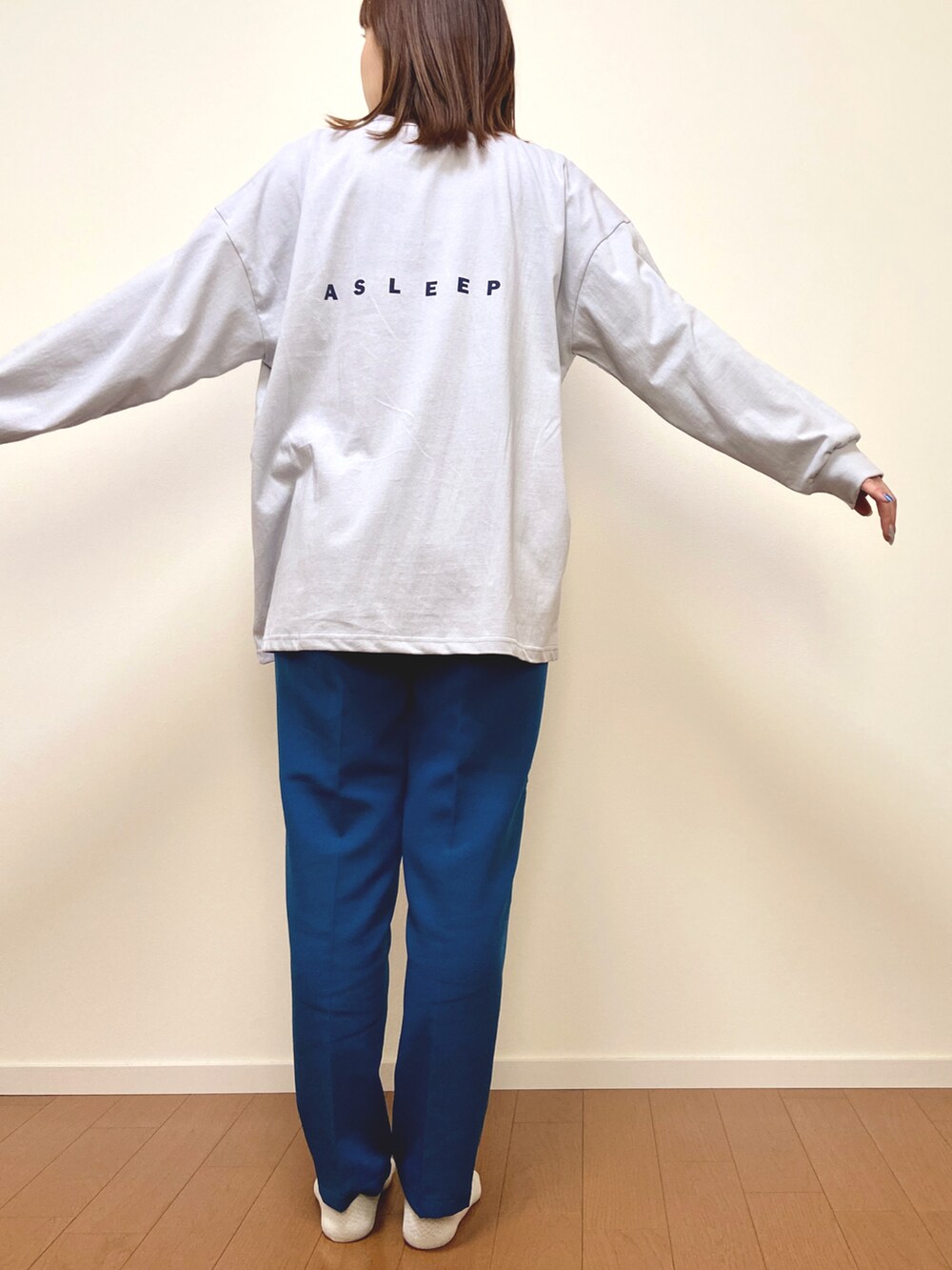 グレー系のTシャツ/カットソー、ブルー系のスラックスを着用したレディースの春コーディネートの2枚目の写真