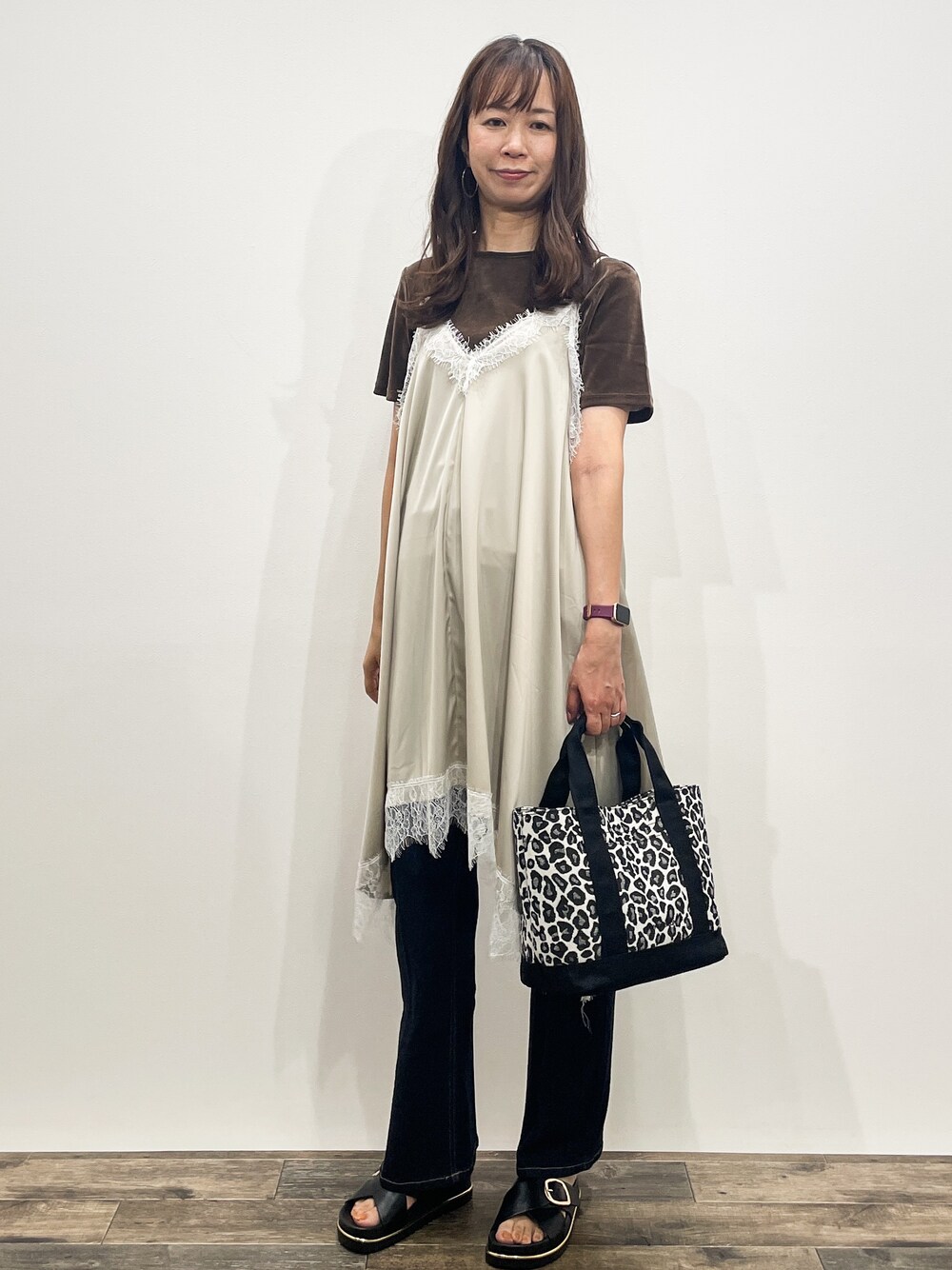 ブラウン系のTシャツ/カットソー、ベージュ系のワンピース、ブルー系のデニムパンツを着用したレディースの夏コーディネートの2枚目の写真