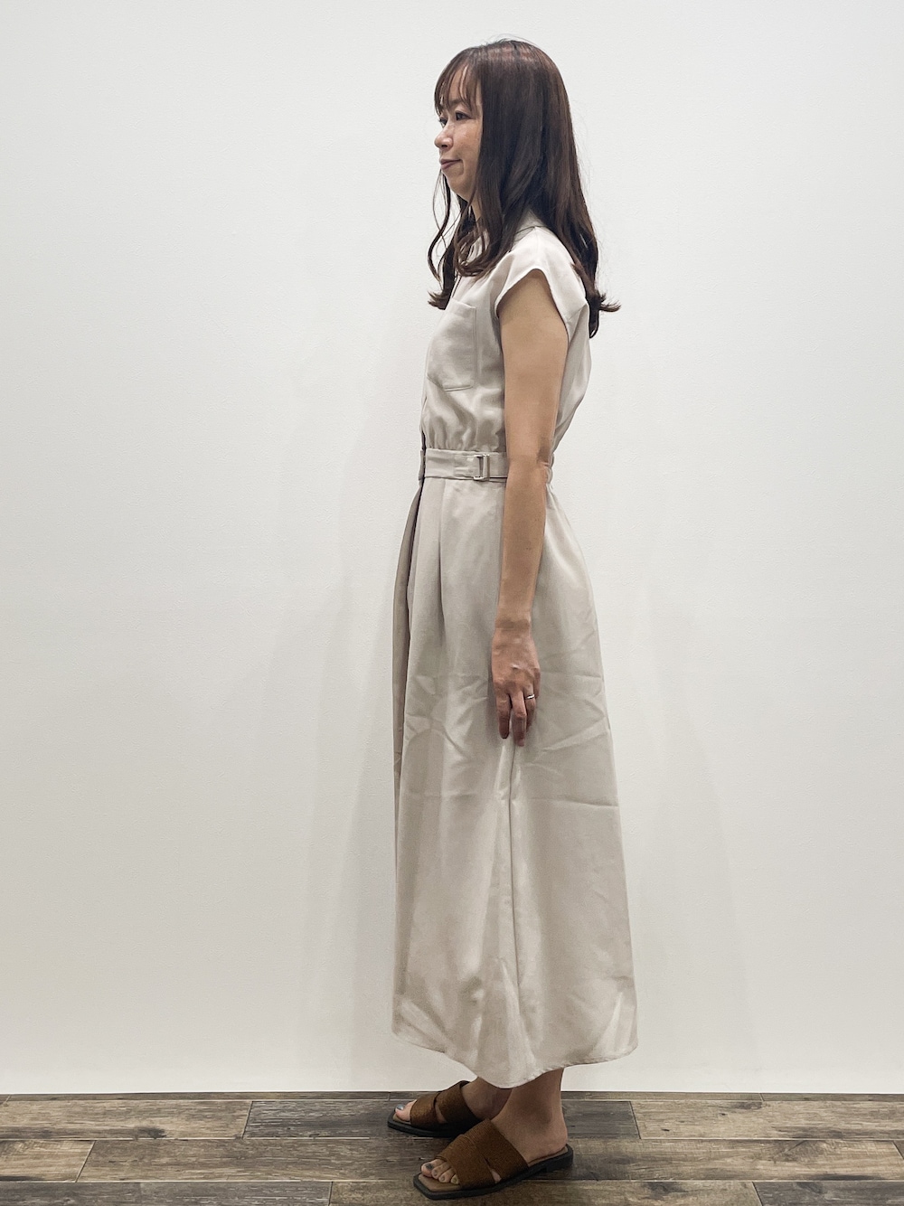 ベージュ系のワンピース、ブラック系のショルダーバッグ、その他のサンダルを着用したレディースの夏コーディネートの3枚目の写真