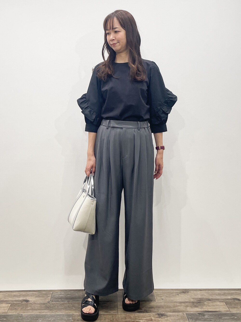 ブラック系のTシャツ/カットソー、グレー系のその他パンツ、シルバー系のトートバッグを着用したレディースの春コーディネートの6枚目の写真