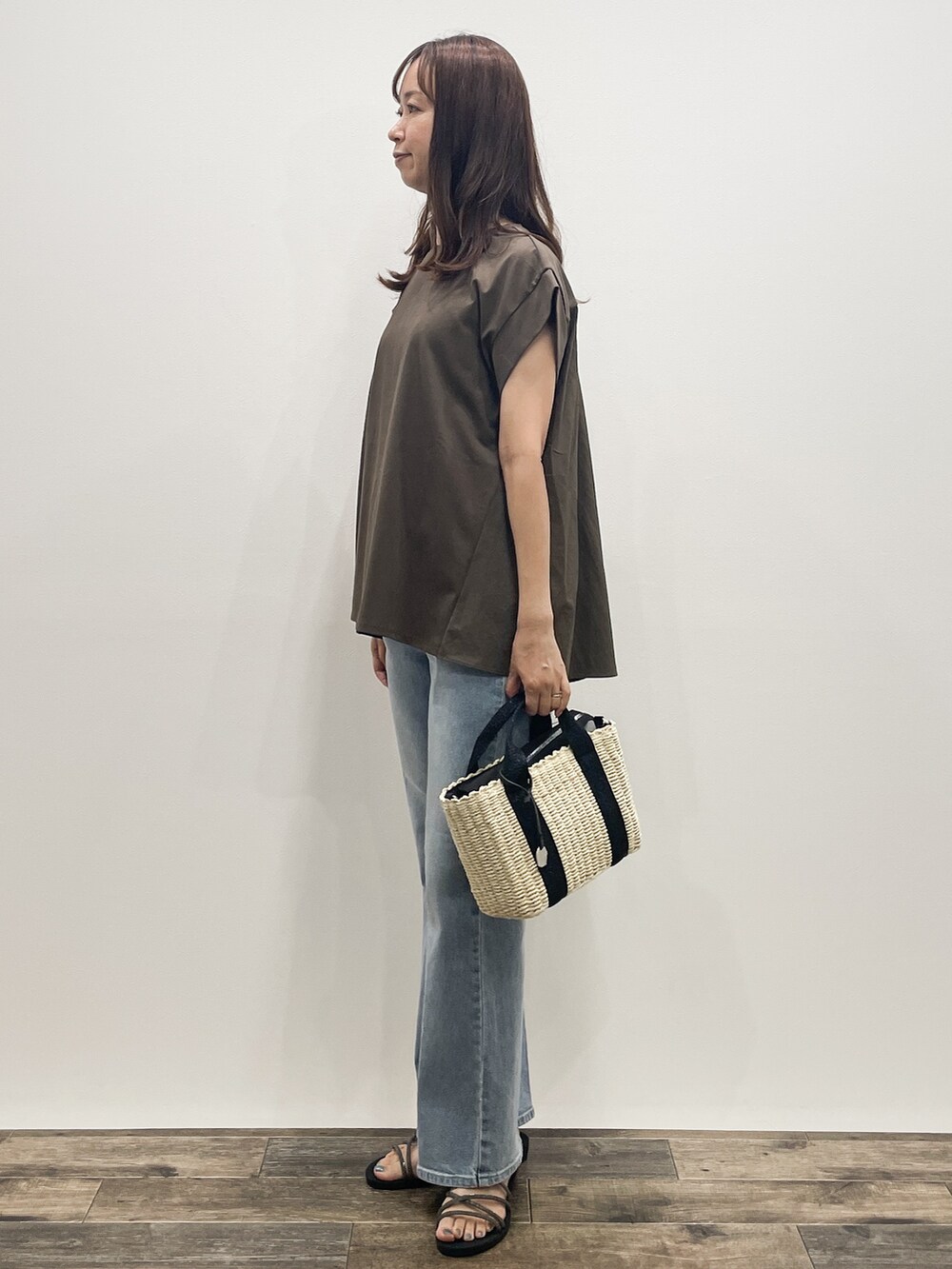 ブラウン系のTシャツ/カットソー、ブルー系のデニムパンツ、ブラック系のトートバッグを着用したレディースの夏コーディネートの3枚目の写真