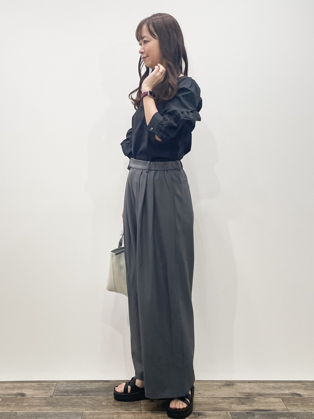 ブラック系のTシャツ/カットソー、グレー系のその他パンツ、シルバー系のトートバッグを着用したレディースの春コーディネートの2枚目の写真