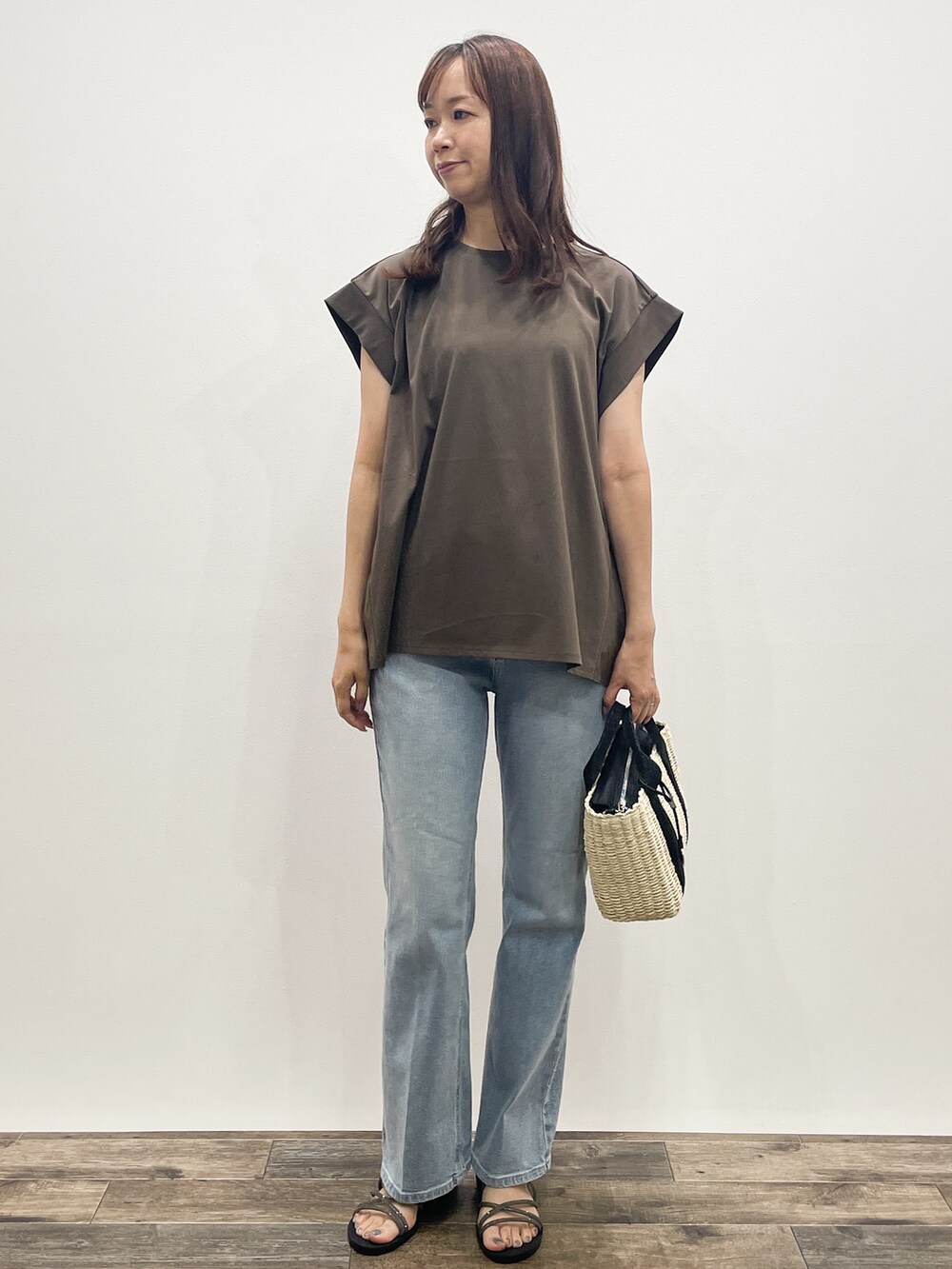 ブラウン系のTシャツ/カットソー、ブルー系のデニムパンツ、ブラック系のトートバッグを着用したレディースの夏コーディネートの2枚目の写真