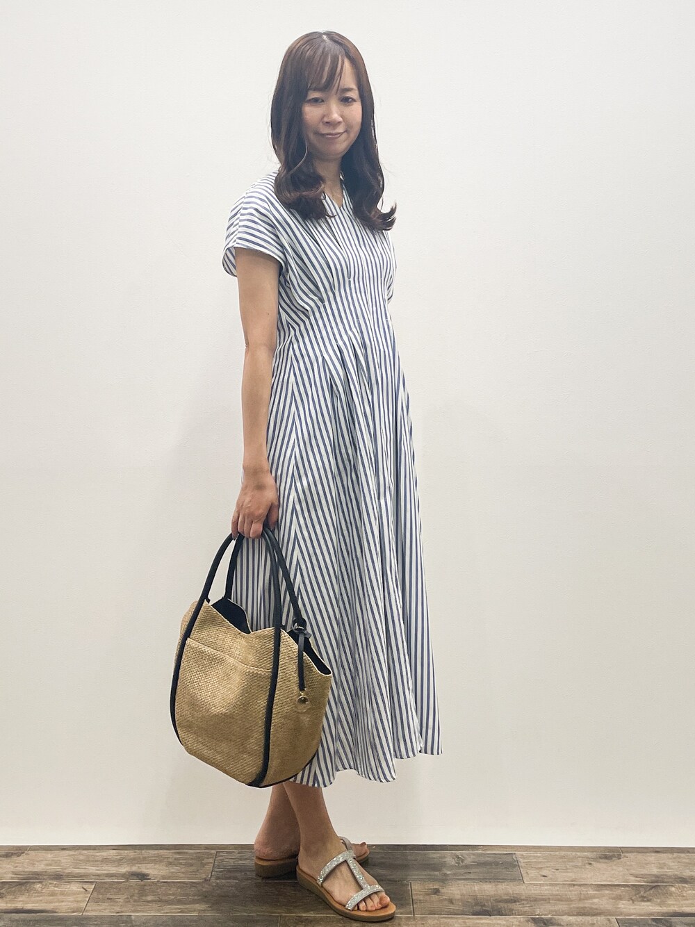 ブルー系のワンピース、ベージュ系のトートバッグ、シルバー系のサンダルを着用したレディースの夏コーディネートの8枚目の写真