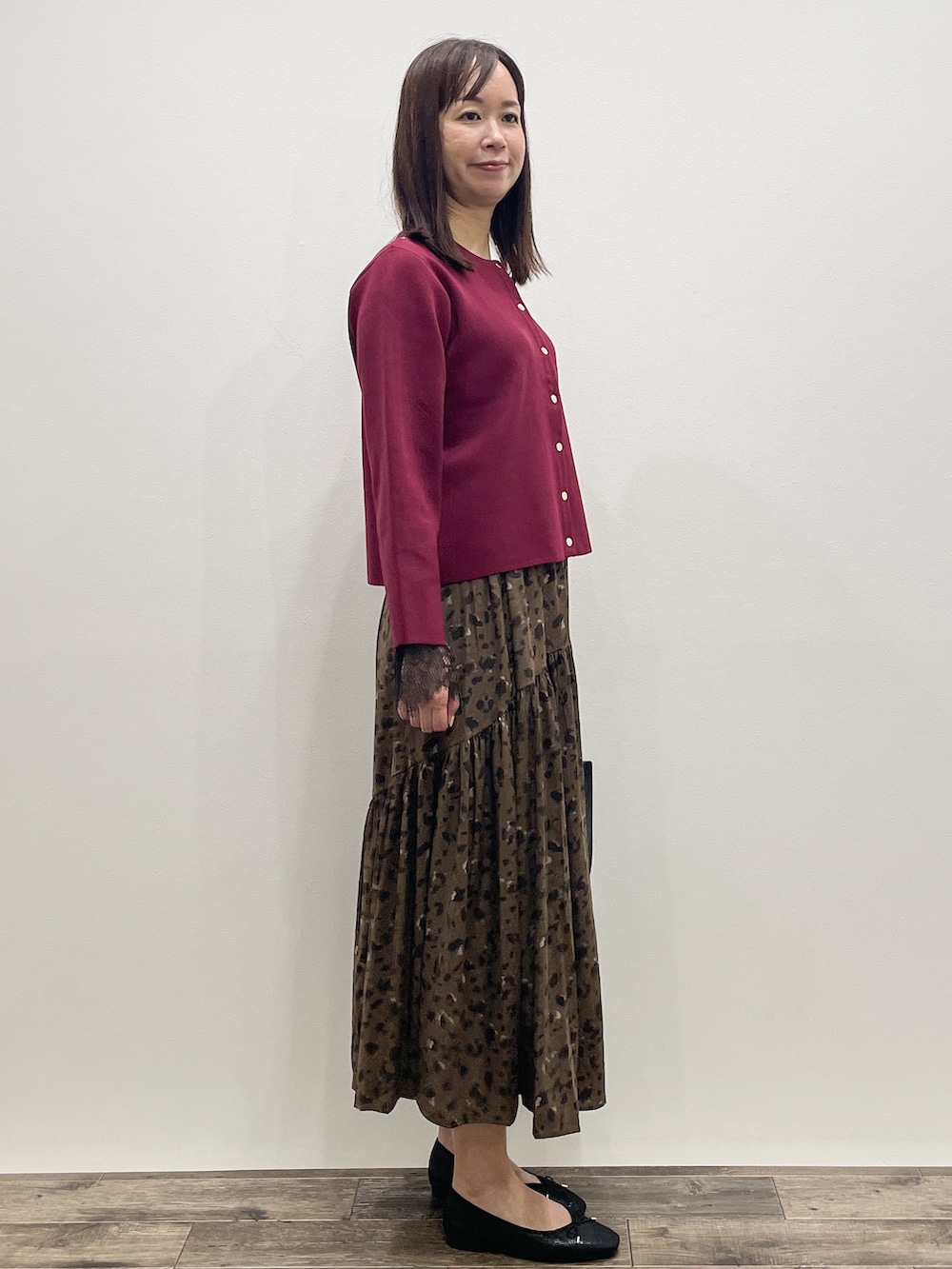 レッド系のカーディガン/ボレロ、グレー系のTシャツ/カットソー、ブラウン系のスカートを着用したレディースの秋コーディネートの8枚目の写真