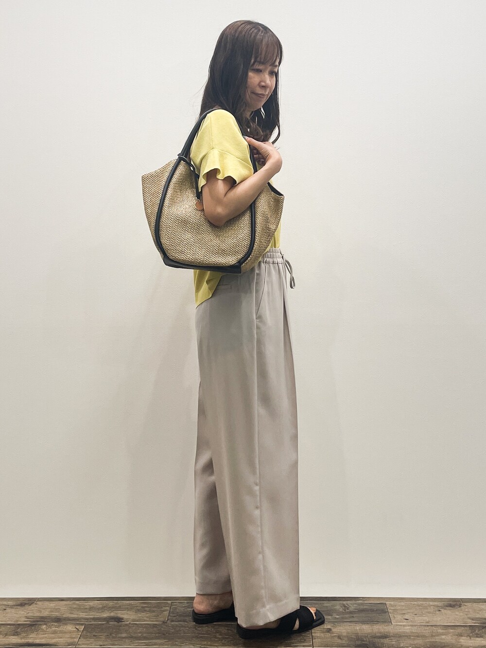 イエロー系のニット/セーター、ベージュ系のその他パンツ、ベージュ系のトートバッグを着用したレディースの春コーディネートの7枚目の写真