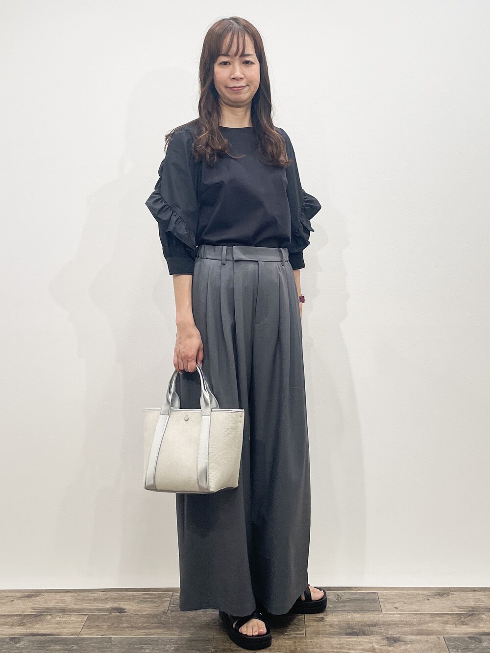 ブラック系のTシャツ/カットソー、グレー系のその他パンツ、シルバー系のトートバッグを着用したレディースの春コーディネートの5枚目の写真