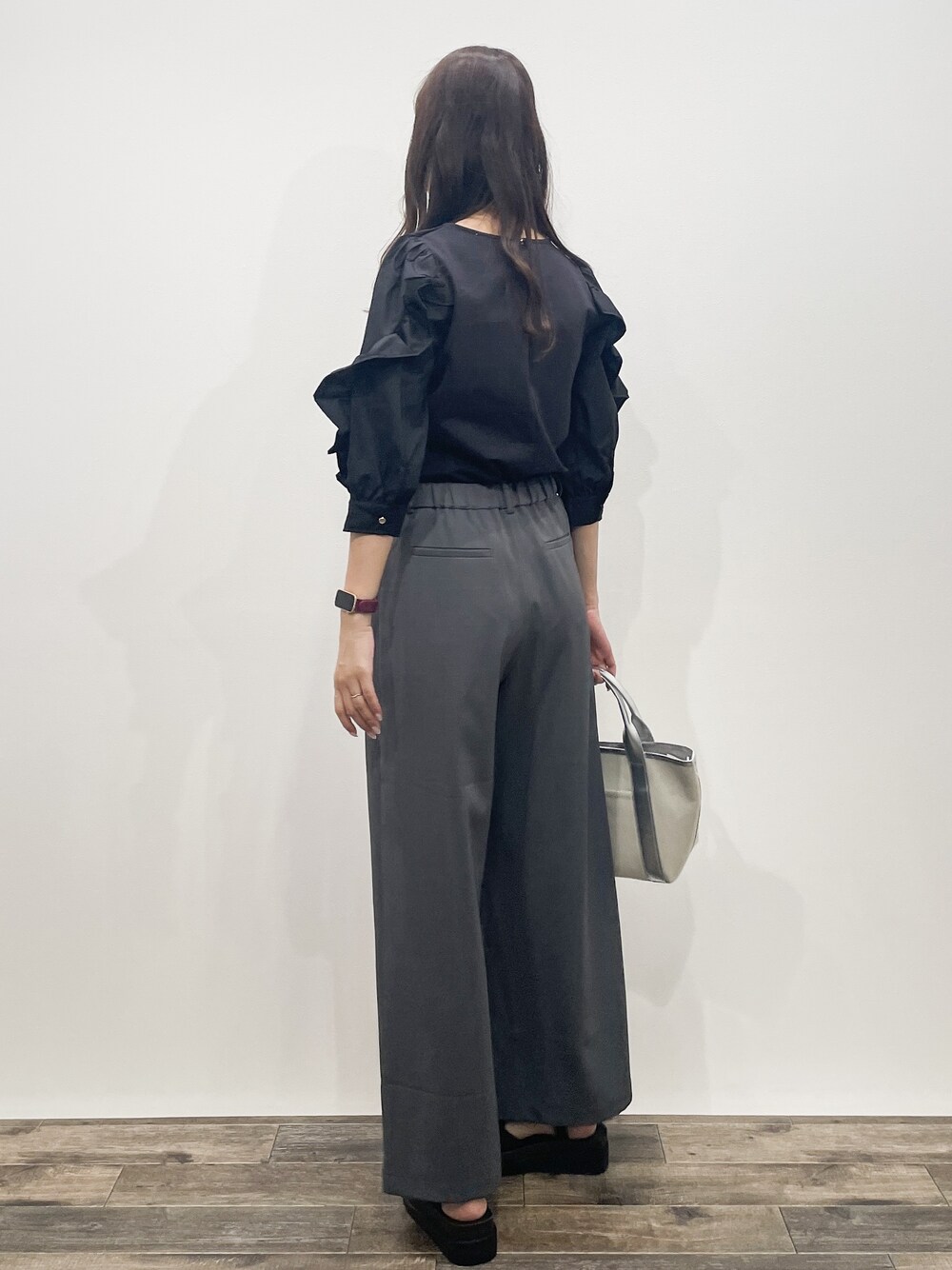 ブラック系のTシャツ/カットソー、グレー系のその他パンツ、シルバー系のトートバッグを着用したレディースの春コーディネートの3枚目の写真