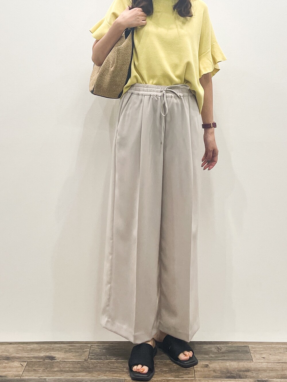イエロー系のニット/セーター、ベージュ系のその他パンツ、ベージュ系のトートバッグを着用したレディースの春コーディネートの9枚目の写真