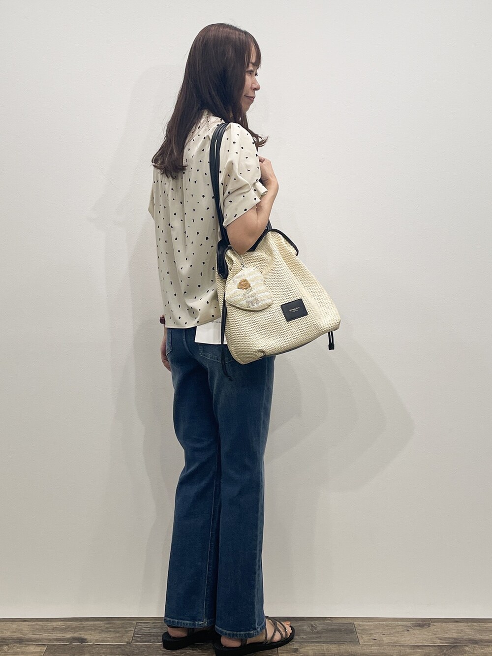 ベージュ系のシャツ/ブラウス、ブルー系のデニムパンツ、ホワイト系のトートバッグを着用したレディースの夏コーディネートの7枚目の写真