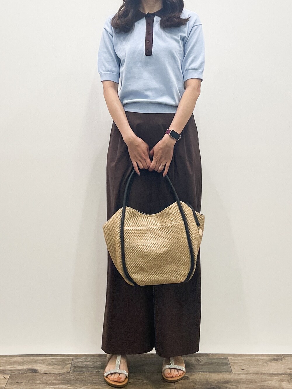 ブルー系のニット/セーター、ブラウン系のその他パンツ、ベージュ系のトートバッグを着用したレディースの春コーディネートの7枚目の写真