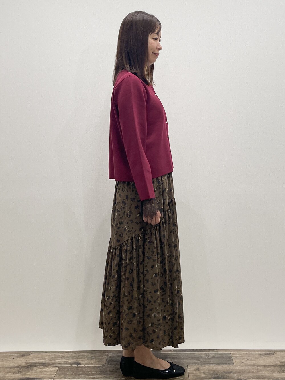 レッド系のカーディガン/ボレロ、グレー系のTシャツ/カットソー、ブラウン系のスカートを着用したレディースの秋コーディネートの7枚目の写真
