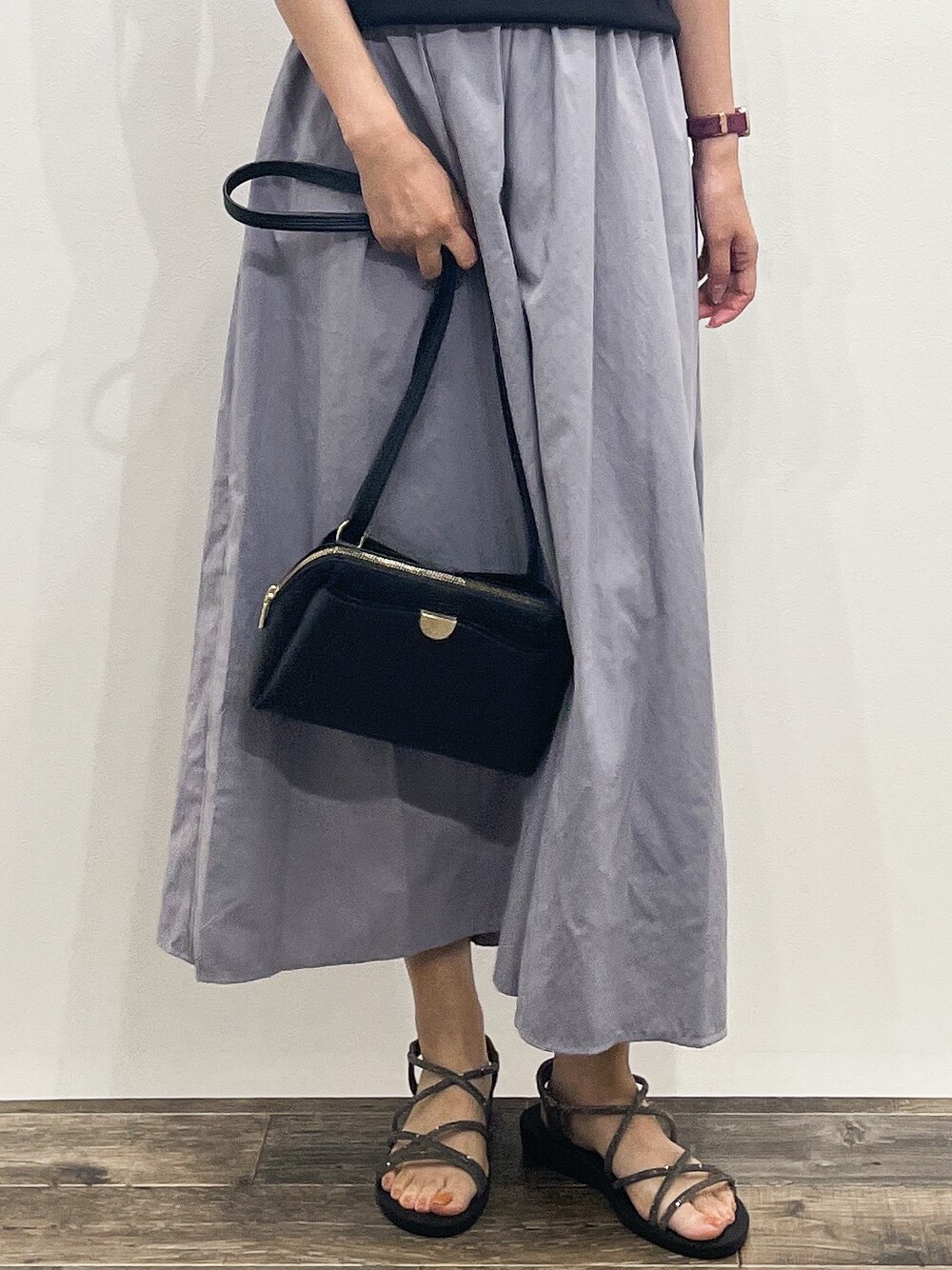 ブラック系のニット/セーター、グレー系のその他パンツ、ブラック系のショルダーバッグを着用したレディースの夏コーディネートの9枚目の写真