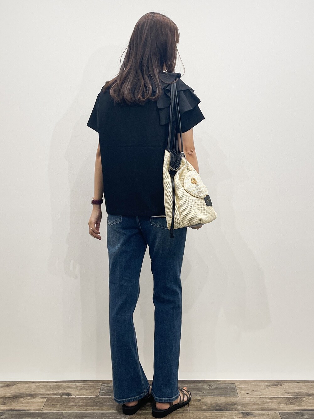 ブラック系のTシャツ/カットソー、ブルー系のデニムパンツ、ホワイト系のトートバッグを着用したレディースの夏コーディネートの6枚目の写真