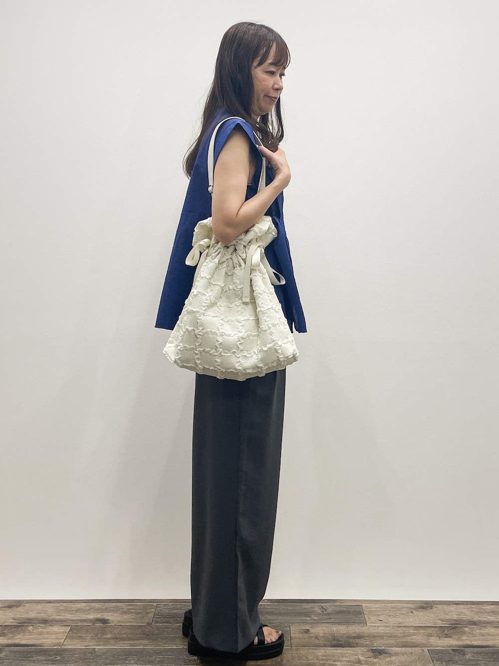 ブルー系のシャツ/ブラウス、グレー系のその他パンツ、ホワイト系のトートバッグを着用したレディースの夏コーディネートの7枚目の写真