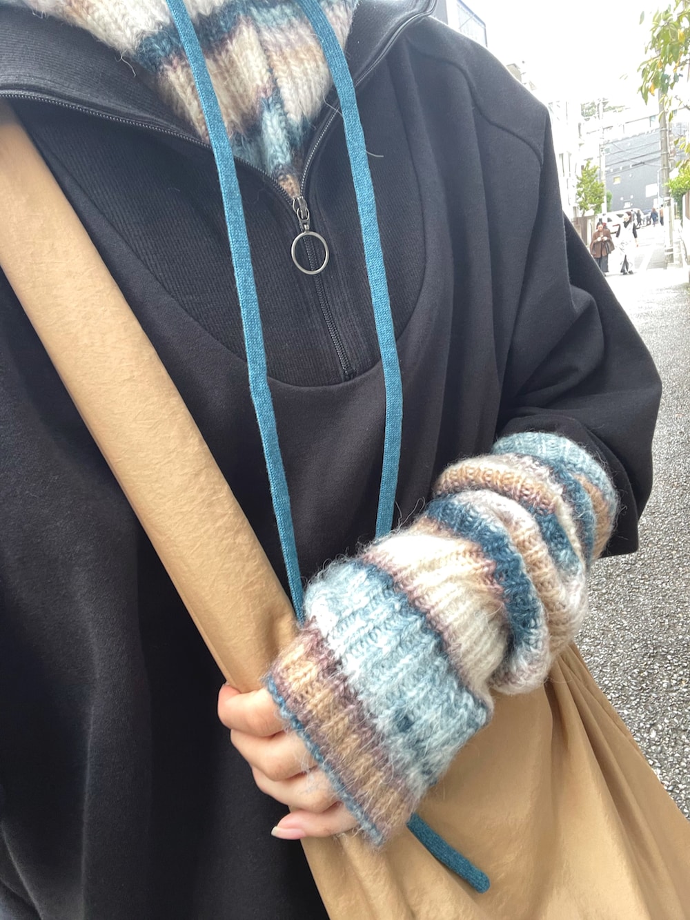 ベージュ系のショルダーバッグ、ブルー系のニット/セーターを着用したレディースの秋コーディネートの4枚目の写真