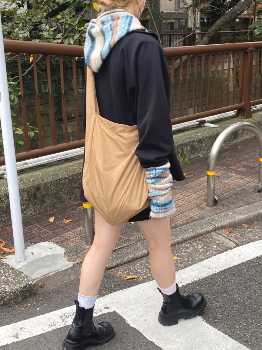 ベージュ系のショルダーバッグ、ブルー系のニット/セーターを着用したレディースの秋コーディネートの2枚目の写真