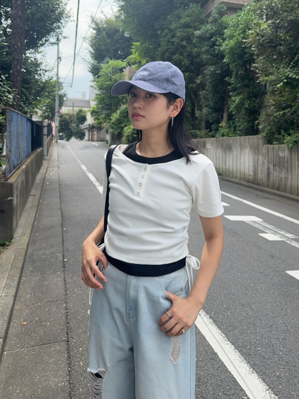 ブルー系のデニムパンツ、ホワイト系のTシャツ/カットソー、ブラック系のローファーを着用したレディースの夏コーディネートの2枚目の写真