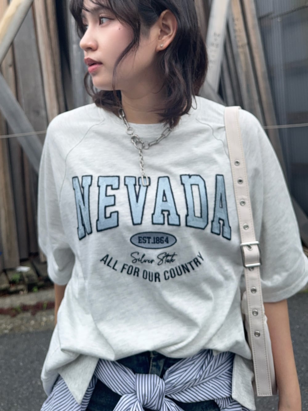 ベージュ系のTシャツ/カットソー、ブルー系のデニムスカート、ブラック系のローファーを着用したレディースの夏コーディネートの3枚目の写真