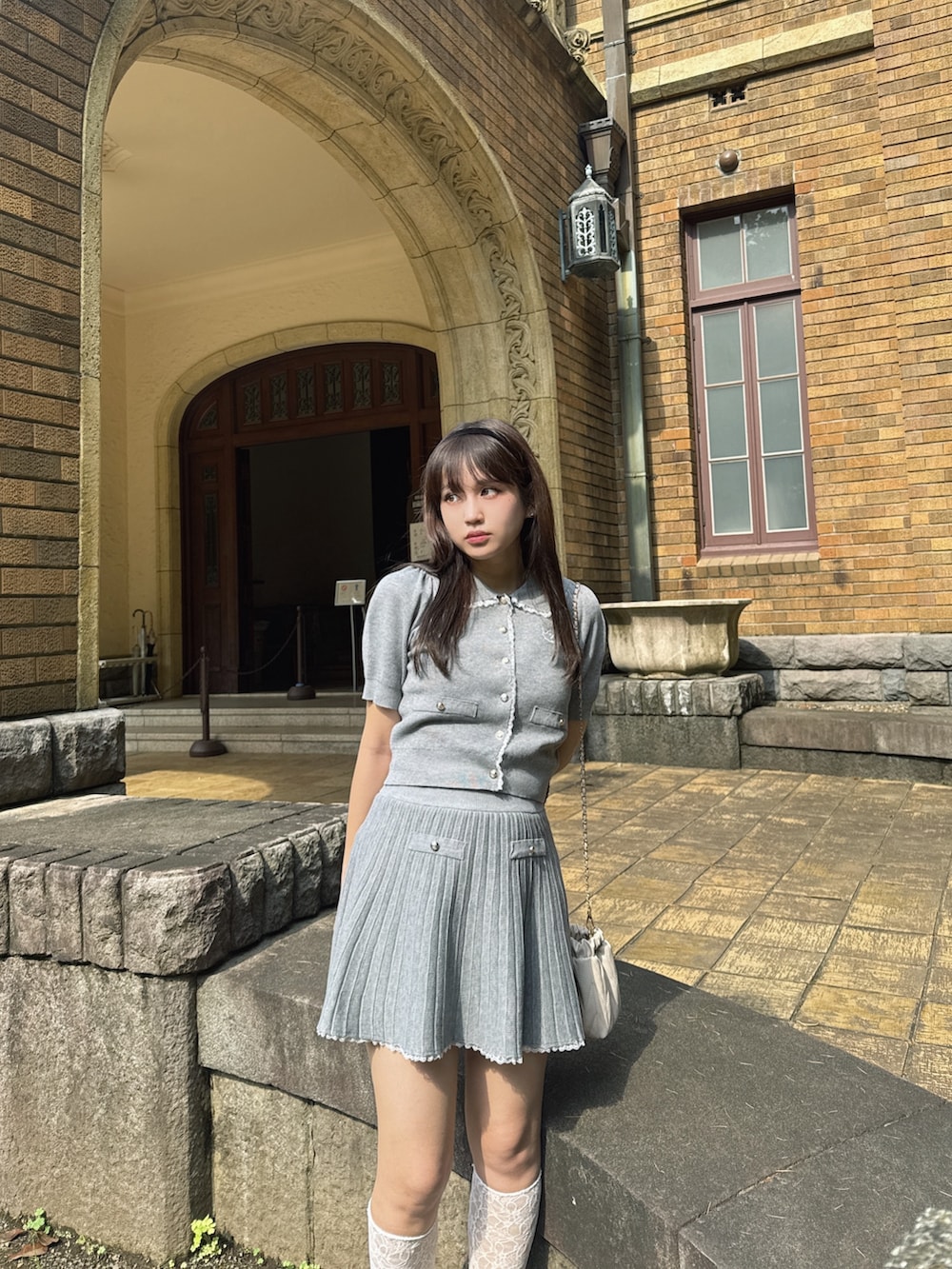 グレー系のセットアップ、ベージュ系のスニーカーを着用したレディースの夏コーディネートの3枚目の写真