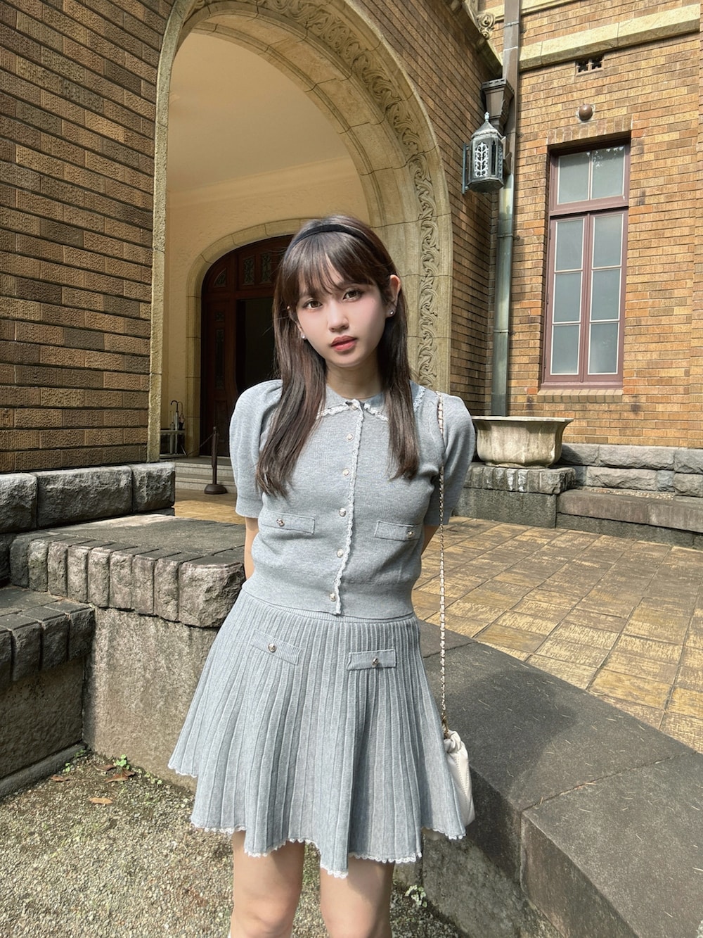 グレー系のセットアップ、ベージュ系のスニーカーを着用したレディースの夏コーディネートの2枚目の写真