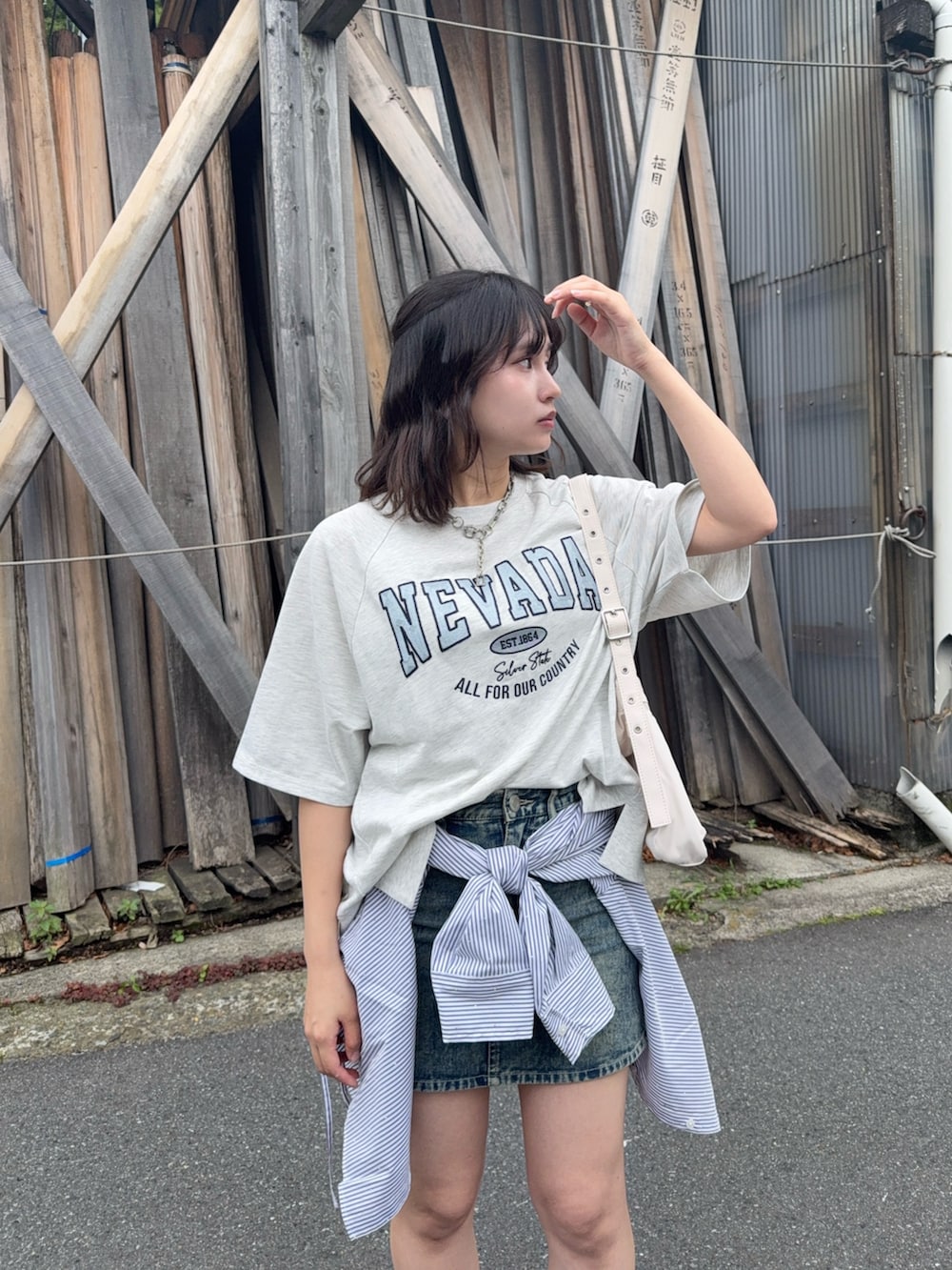ベージュ系のTシャツ/カットソー、ブルー系のデニムスカート、ブラック系のローファーを着用したレディースの夏コーディネートの4枚目の写真