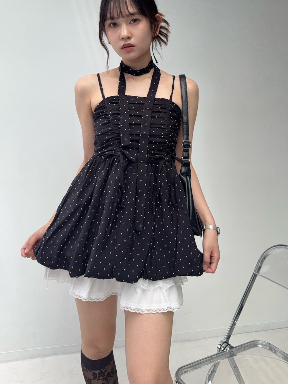 ブラック系のチュニック、ホワイト系のスカート、ブラック系のサンダルを着用したレディースの夏コーディネートの5枚目の写真
