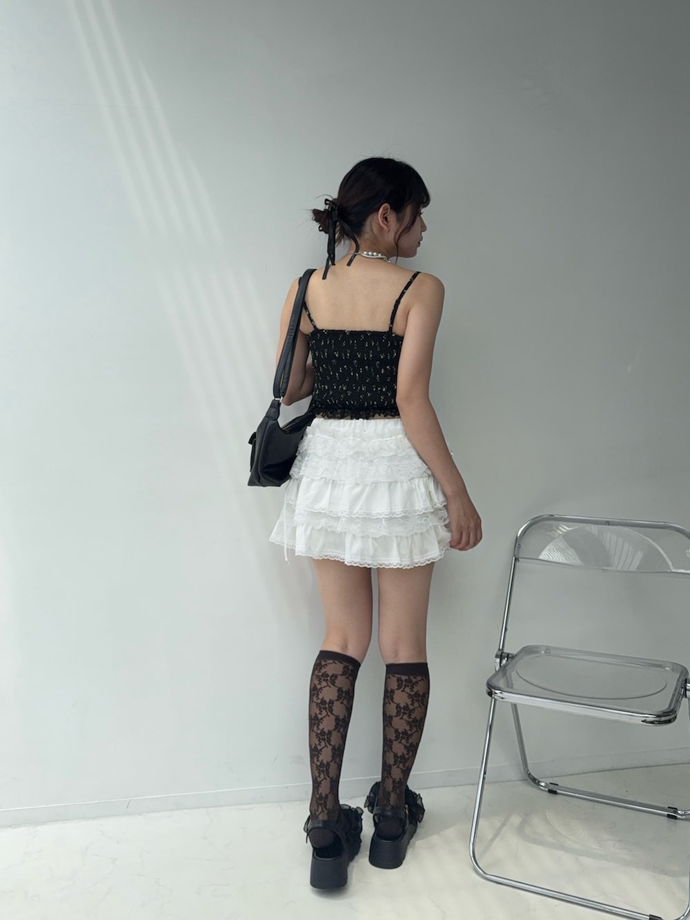 ホワイト系のスカート、ブラック系のシャツ/ブラウス、ブラック系のサンダルを着用したレディースの夏コーディネートの2枚目の写真