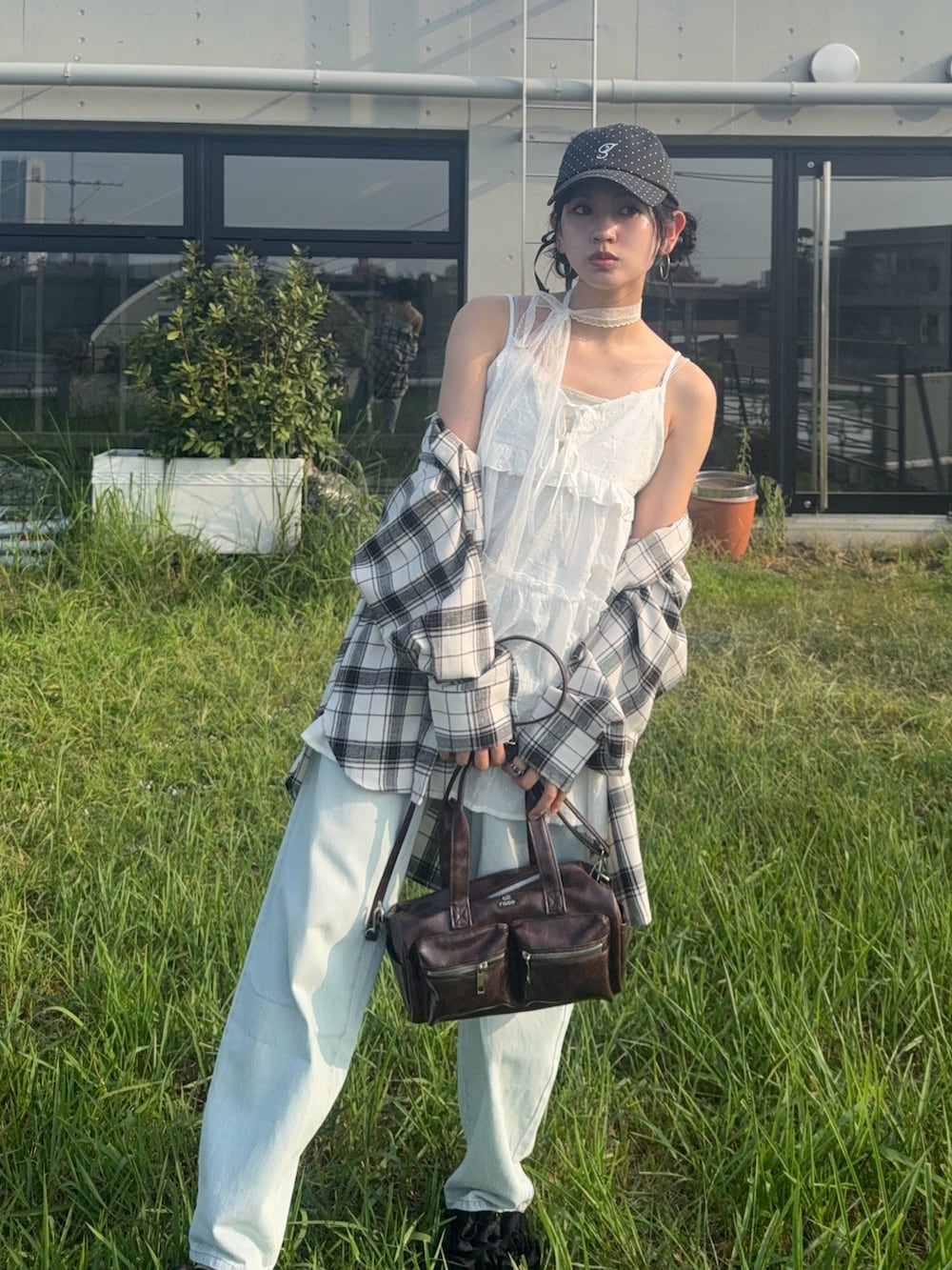 ホワイト系のチュニック、ブルー系のデニムパンツ、ブラック系のサンダルを着用したレディースの夏コーディネートの2枚目の写真