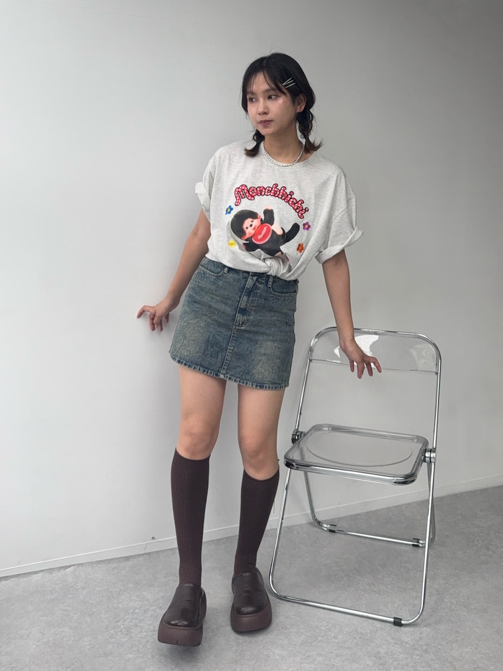 ブルー系のデニムスカート、ベージュ系のTシャツ/カットソー、ブラウン系のサンダルを着用したレディースの夏コーディネートの3枚目の写真