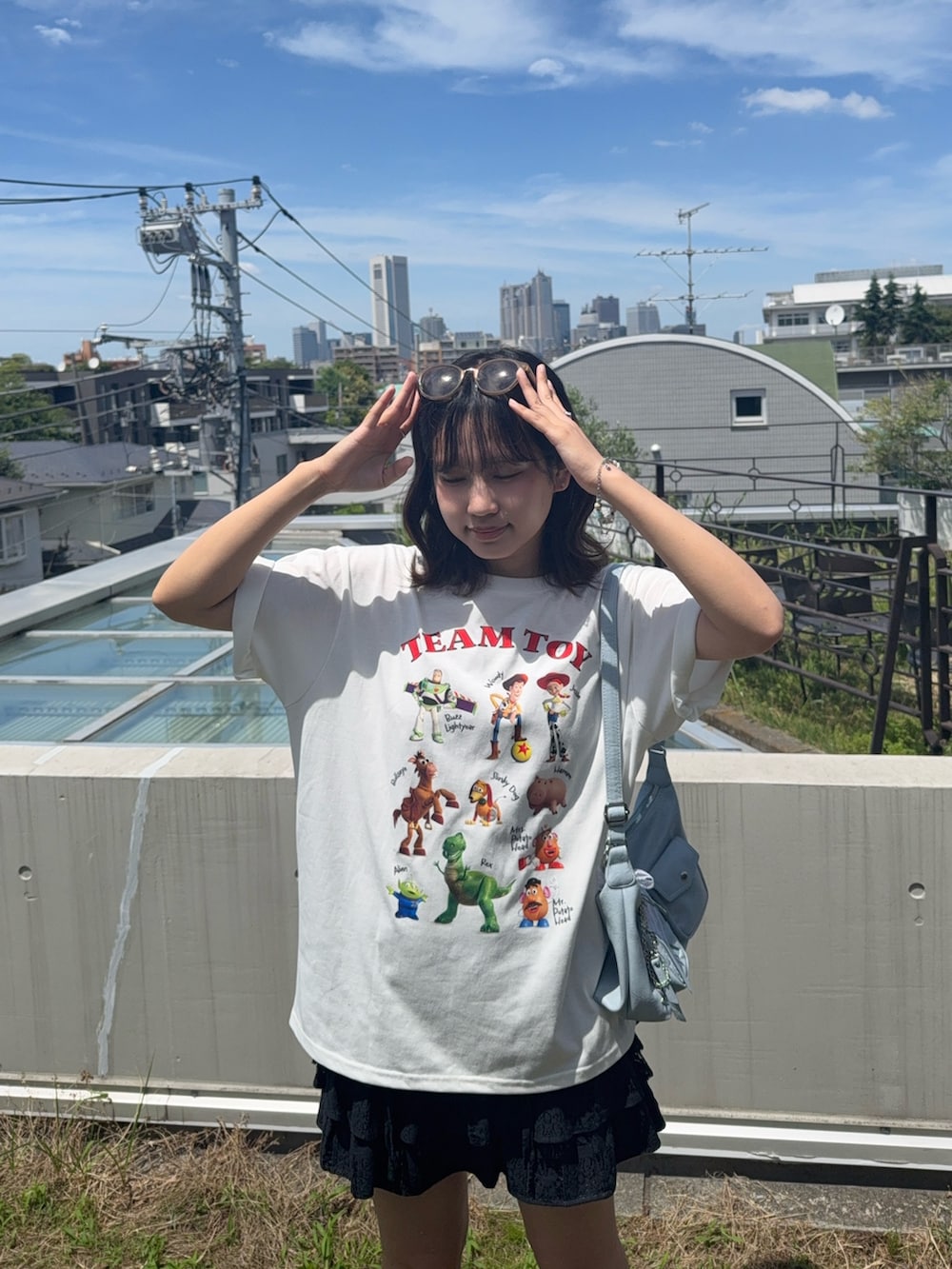 ホワイト系のTシャツ/カットソー、ブラック系のスカート、ブラック系のサンダルを着用したレディースの夏コーディネートの2枚目の写真