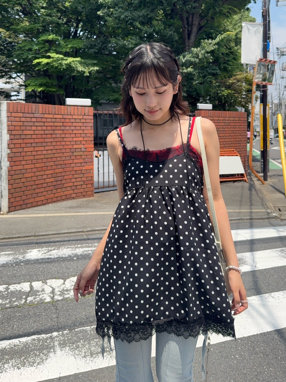 ブラック系のチュニック、ブルー系のデニムパンツ、レッド系のキャミソールを着用したレディースの夏コーディネートの4枚目の写真
