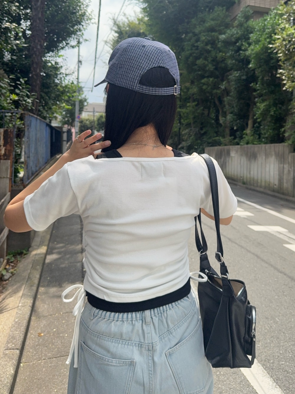 ブルー系のデニムパンツ、ホワイト系のTシャツ/カットソー、ブラック系のローファーを着用したレディースの夏コーディネートの4枚目の写真
