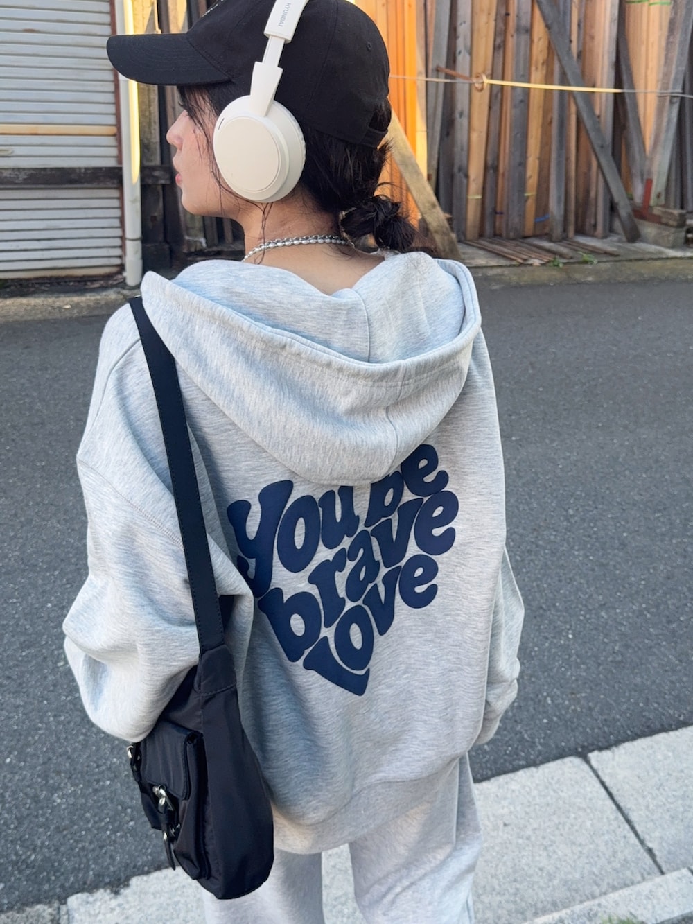 グレー系のパーカー、グレー系のスウェットパンツ、ブラック系のローファーを着用したレディースの夏コーディネートの4枚目の写真