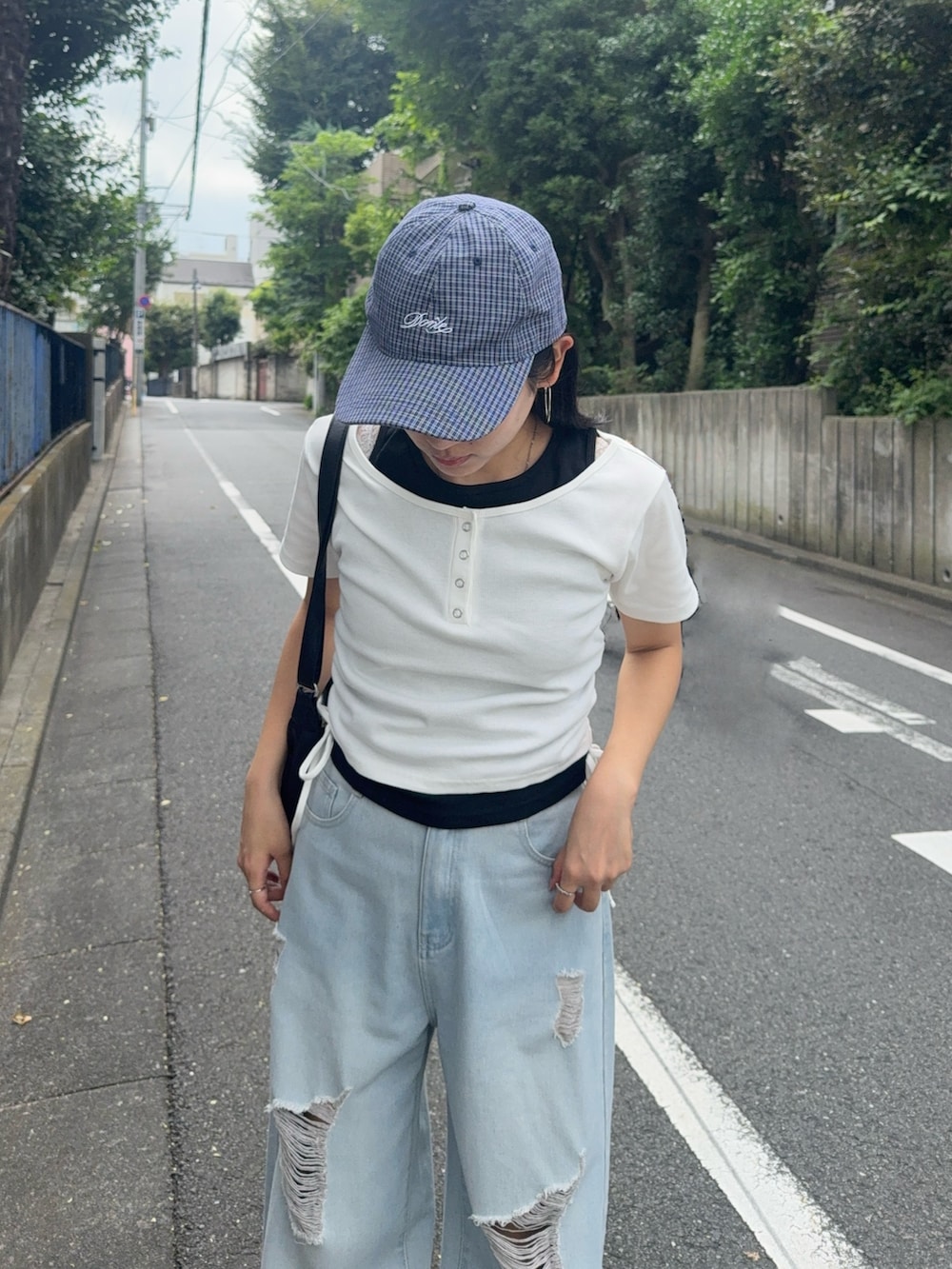 ブルー系のデニムパンツ、ホワイト系のTシャツ/カットソー、ブラック系のローファーを着用したレディースの夏コーディネートの3枚目の写真
