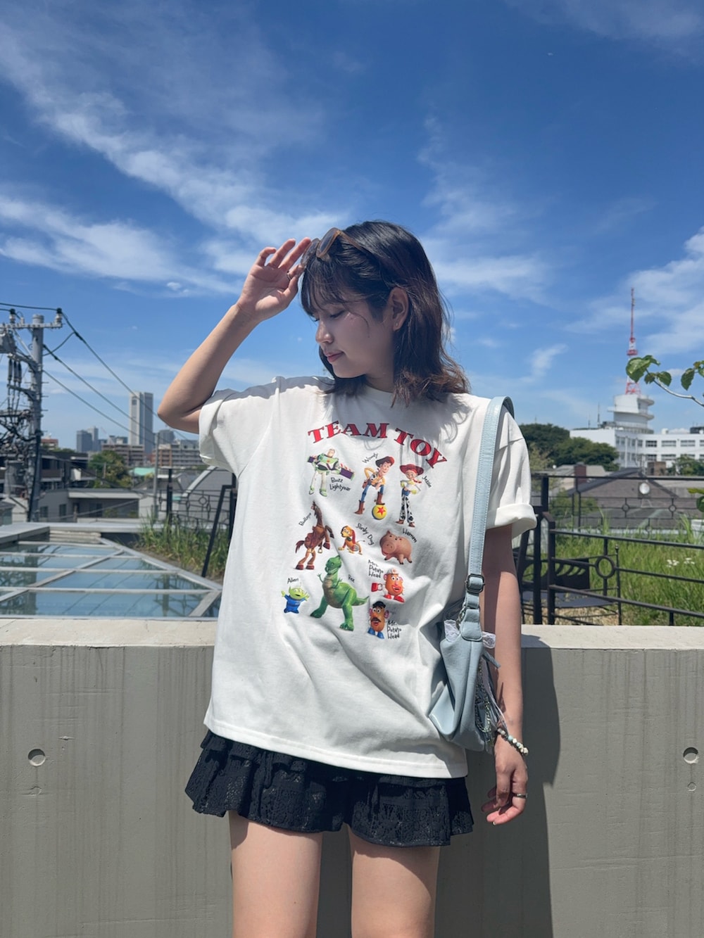 ホワイト系のTシャツ/カットソー、ブラック系のスカート、ブラック系のサンダルを着用したレディースの夏コーディネートの3枚目の写真