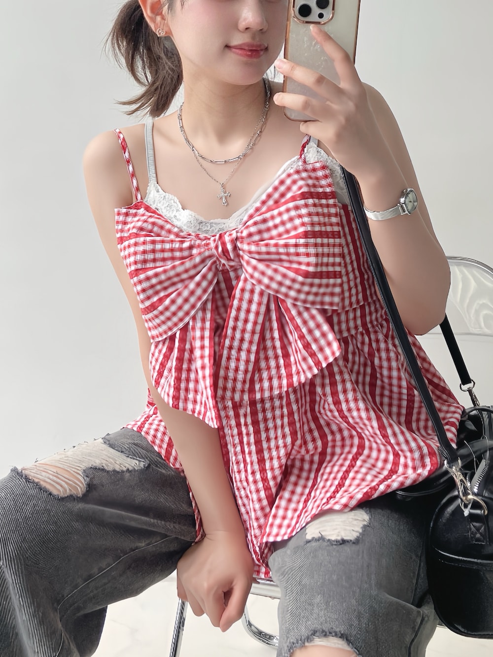 レッド系のチュニック、ブラック系のデニムパンツ、ブラウン系のサンダルを着用したレディースの夏コーディネートの2枚目の写真