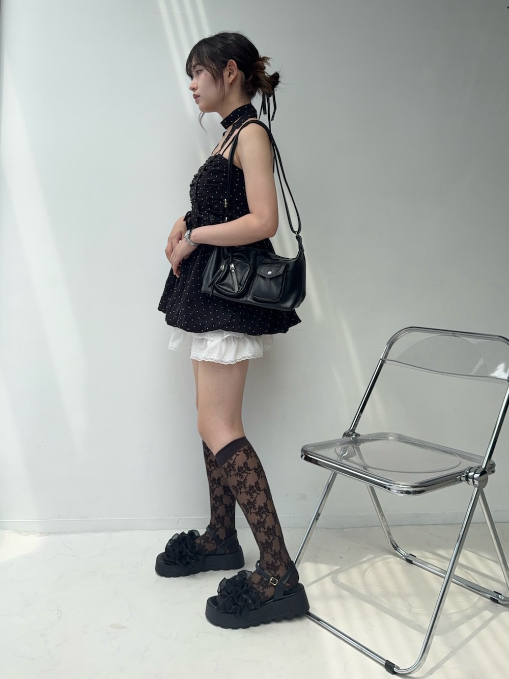 ブラック系のチュニック、ホワイト系のスカート、ブラック系のサンダルを着用したレディースの夏コーディネートの3枚目の写真