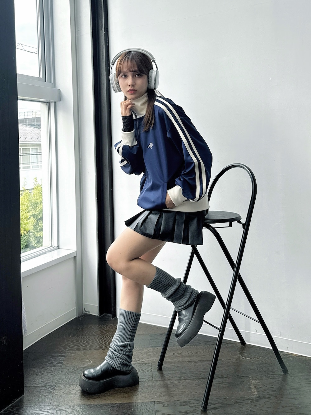 ブルー系のジャージ、ブラック系のスカート、ブラック系のサンダルを着用したレディースの秋コーディネートの2枚目の写真