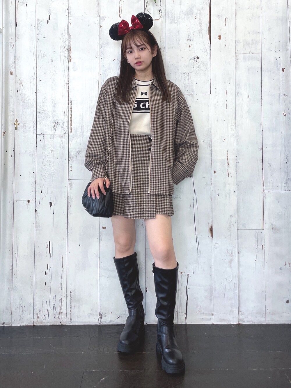 ブラック系のショルダーバッグ、ブラック系のブーツ、ホワイト系のニット/セーターを着用したレディースの秋コーディネートの2枚目の写真