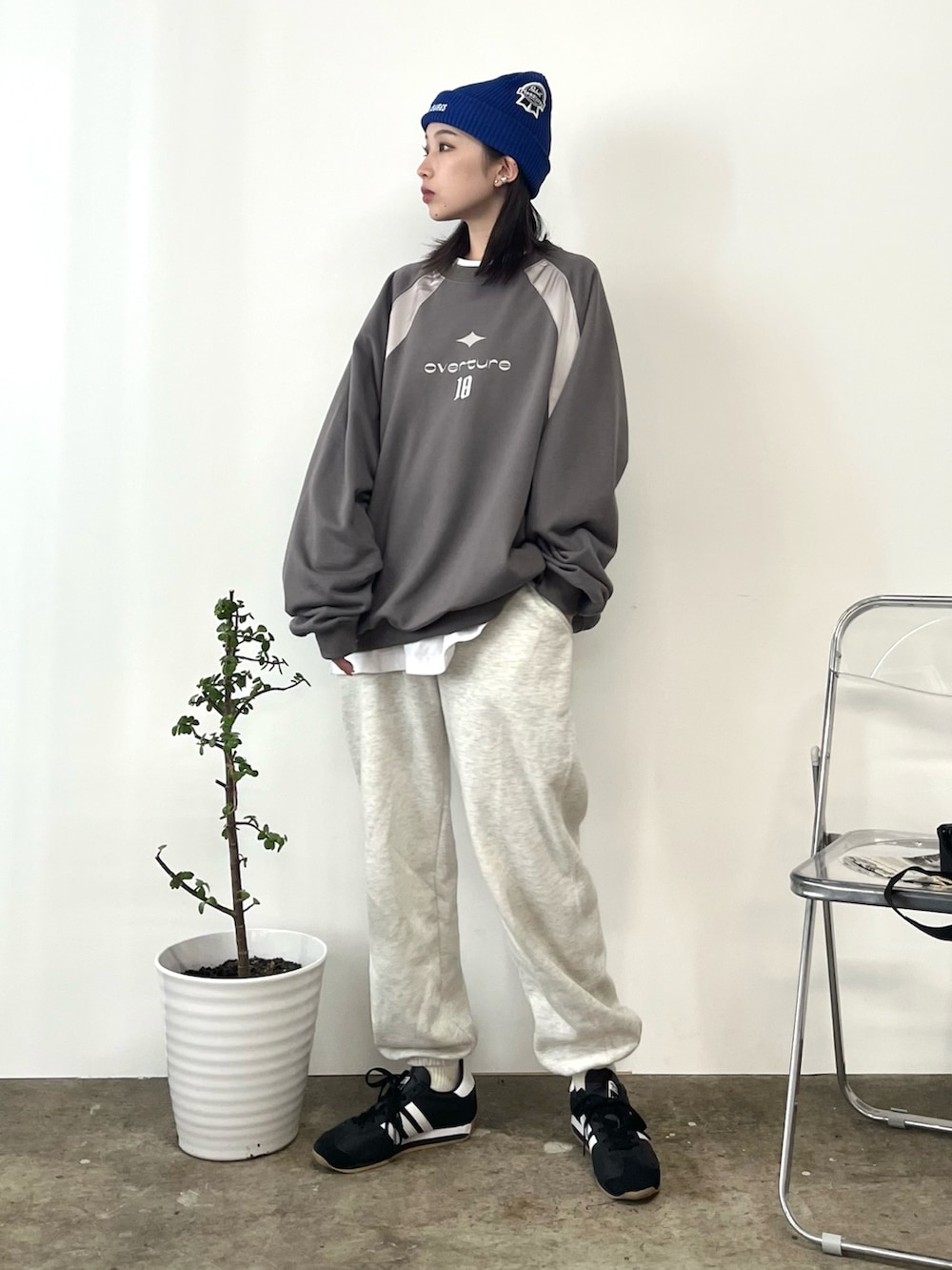 ベージュ系のスウェットパンツ、ブラック系のスニーカー、グレー系のスウェットを着用したレディースの冬コーディネートの2枚目の写真