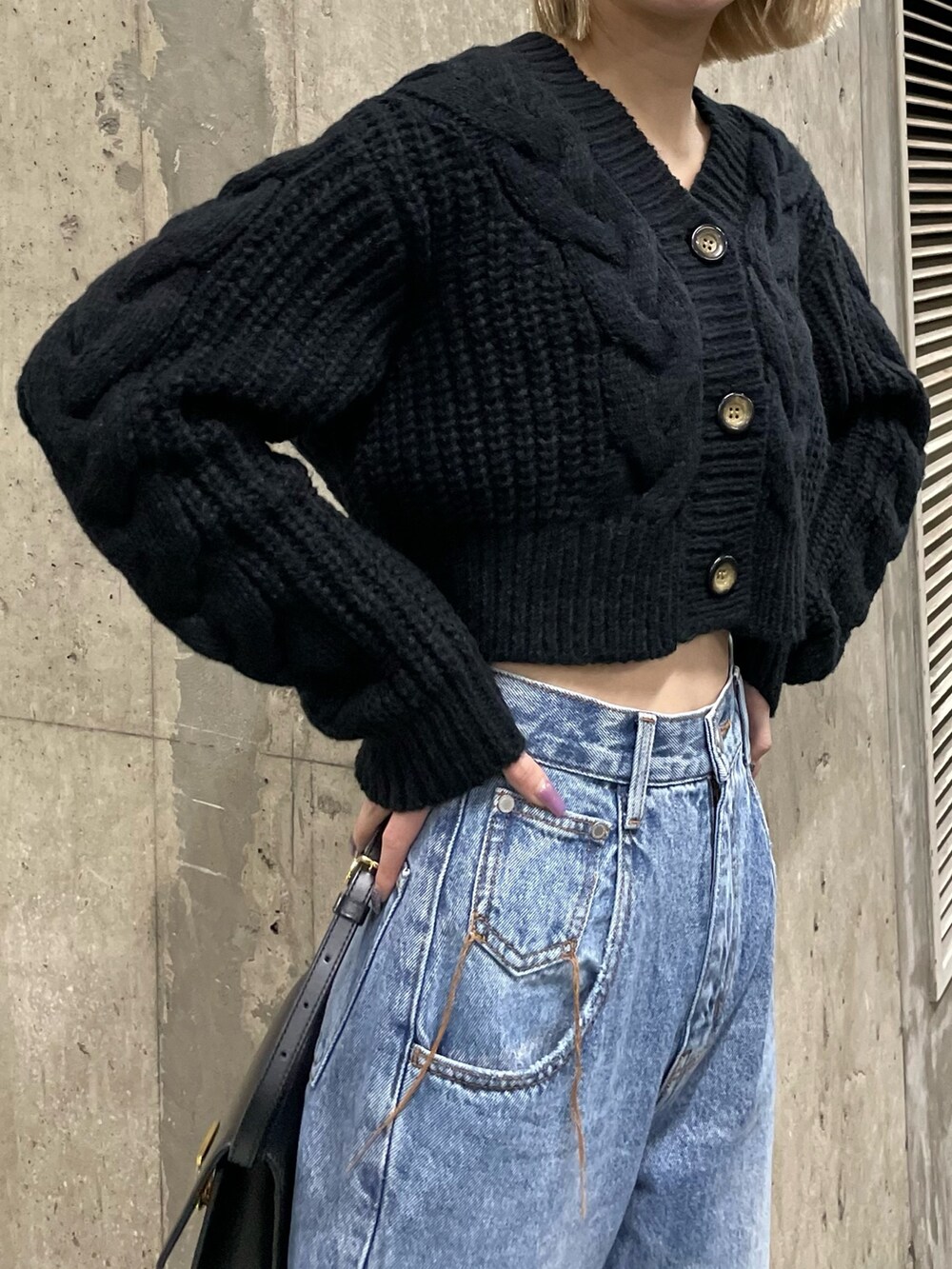 ブラック系のカーディガン/ボレロ、ブルー系のデニムパンツを着用したレディースの秋コーディネートの2枚目の写真