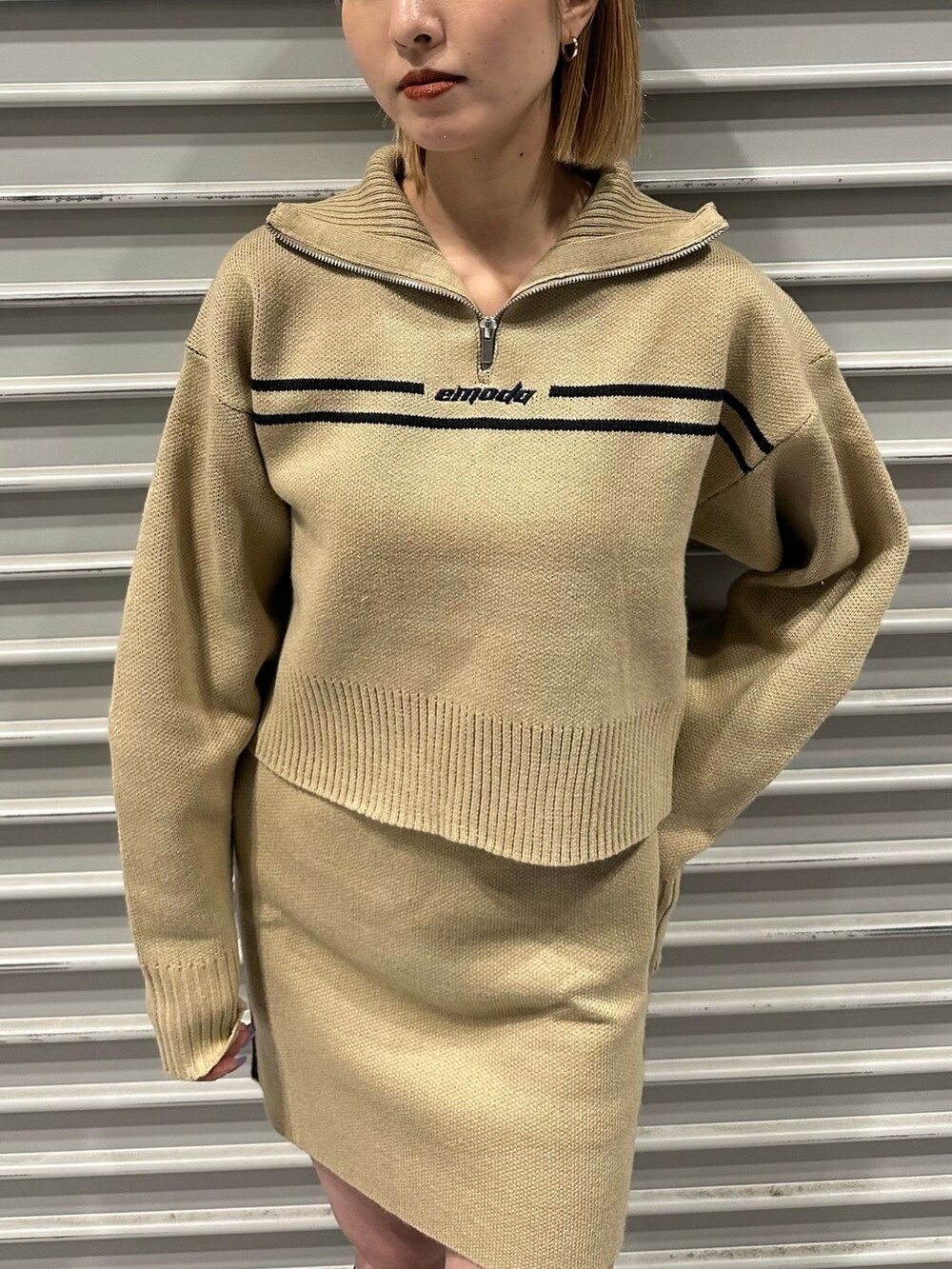 ベージュ系のニット/セーター、ベージュ系のスカート、その他のブーツを着用したレディースの秋コーディネートの2枚目の写真