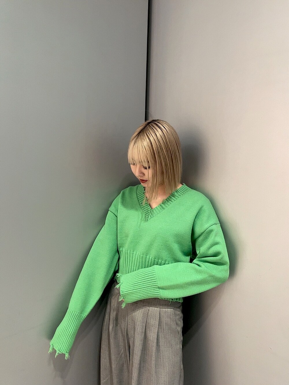 グリーン系のニット/セーター、グレー系のその他パンツを着用したレディースの冬コーディネートの2枚目の写真