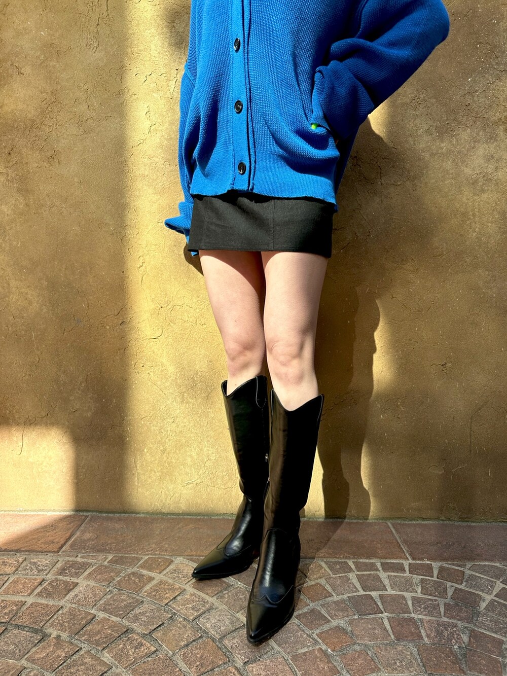 ブラック系のブーツ、ブルー系のカーディガン/ボレロを着用したレディースの冬コーディネートの3枚目の写真