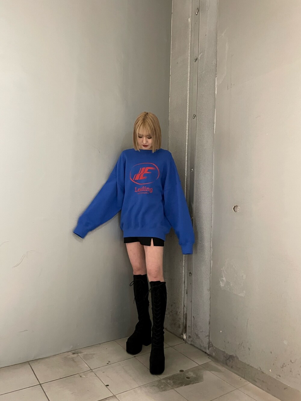 ブルー系のスウェット、ブラック系のブーツを着用したレディースの冬コーディネートの2枚目の写真