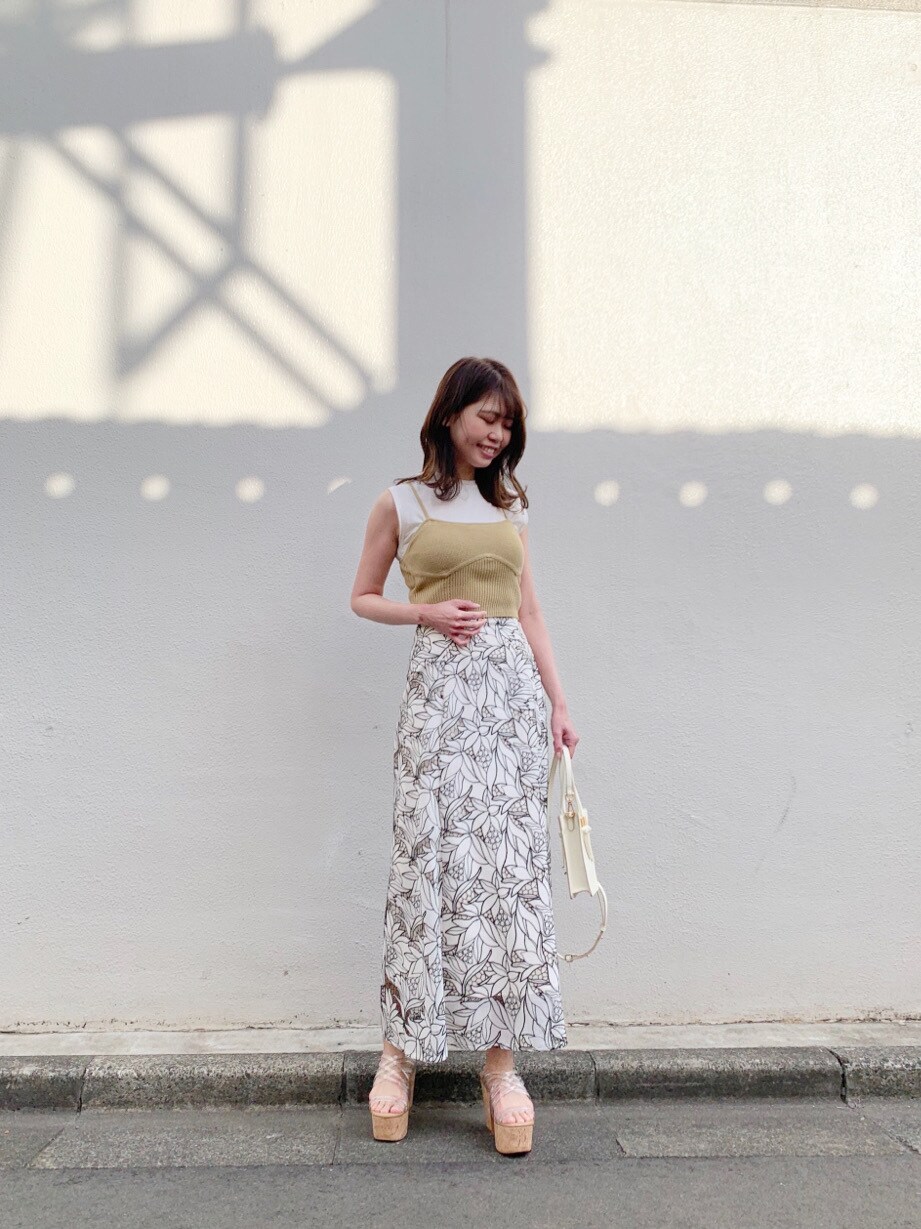 イエロー系のニット/セーター、ホワイト系のハンドバッグ、その他のサンダルを着用したレディースの冬コーディネートの2枚目の写真